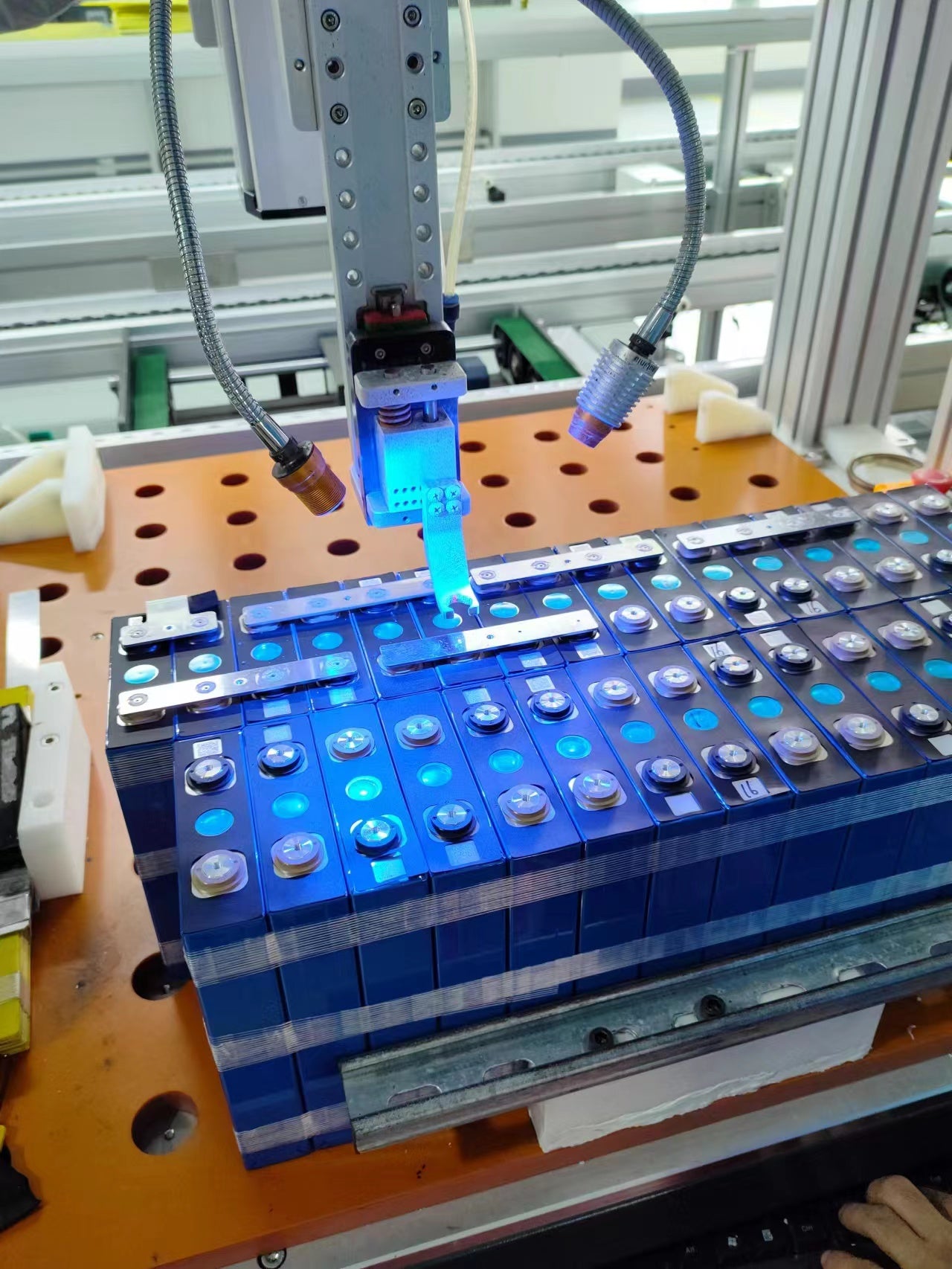 Automated precision laser welding of Topway brand battery cells, highlighting advanced manufacturing technology for battery assembly in a clean factory environment.